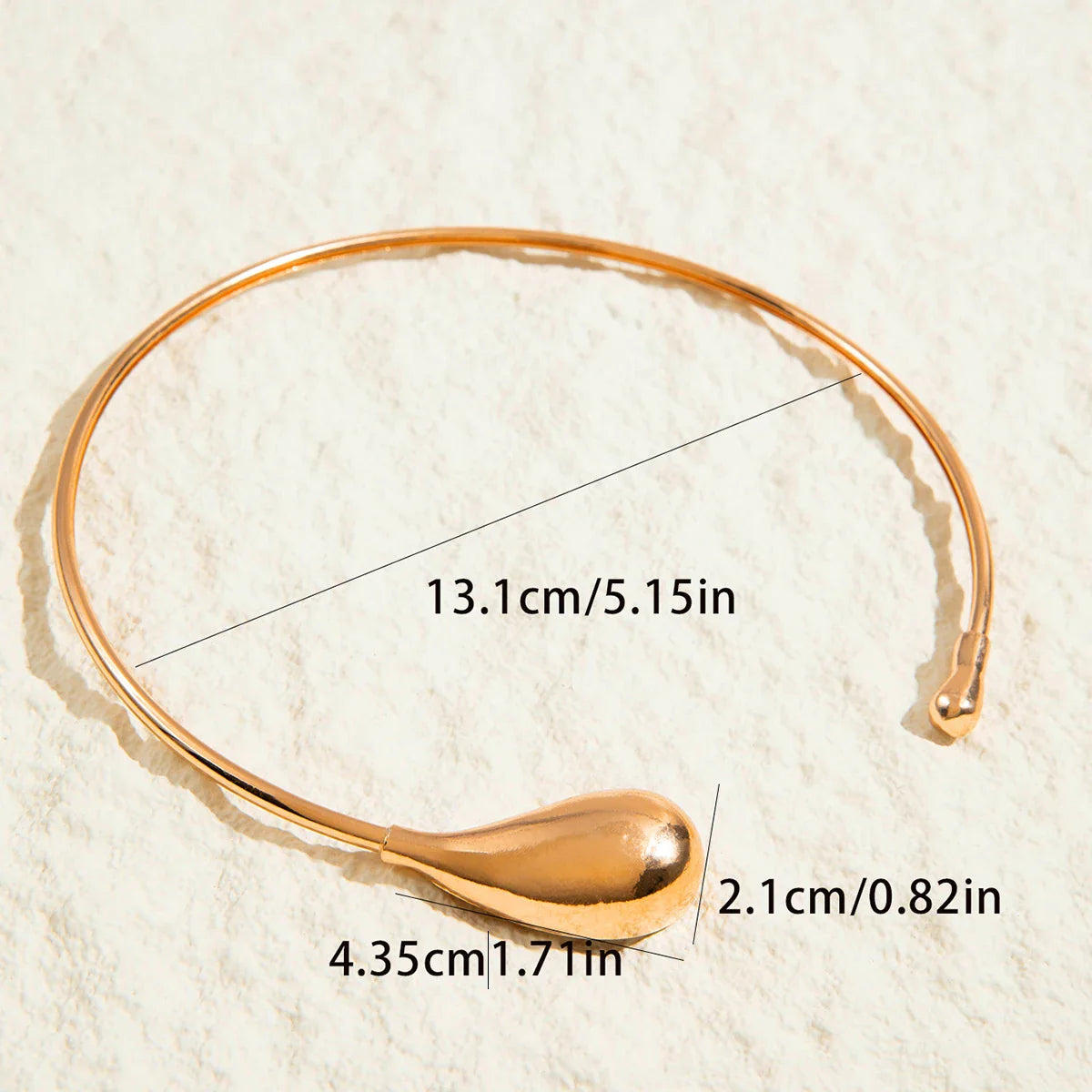 Gold geometric zinc alloy choker necklace for women with teardrop detail and size measurements on textured background